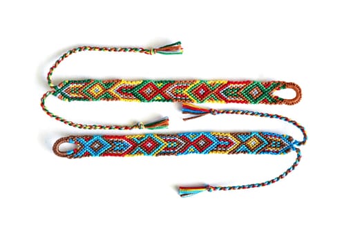Multicolored woven DIY friendship bracelets handmade of embroidery bright thread with knots isolated on white background