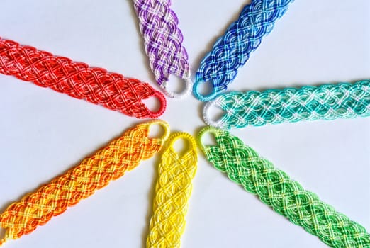 Multicolored woven DIY friendship bracelets handmade of embroidery bright thread with knots isolated on white background