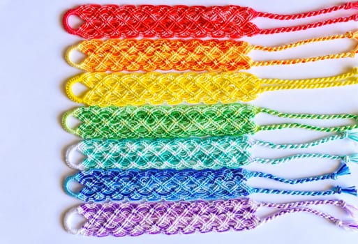 Multicolored woven DIY friendship bracelets handmade of embroidery bright thread with knots isolated on white background
