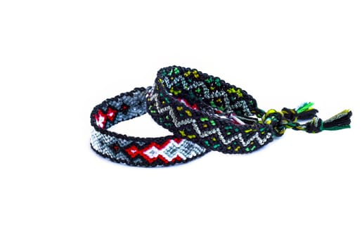 Multicolored woven DIY friendship bracelets handmade of embroidery bright thread with knots isolated on white background