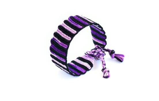 Multicolored woven DIY friendship bracelets handmade of embroidery bright thread with knots isolated on white background