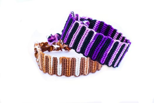 Multicolored woven DIY friendship bracelets handmade of embroidery bright thread with knots isolated on white background