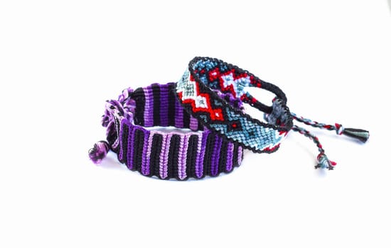 Multicolored woven DIY friendship bracelets handmade of embroidery bright thread with knots isolated on white background