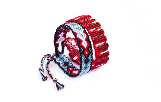 Multicolored woven DIY friendship bracelets handmade of embroidery bright thread with knots isolated on white background