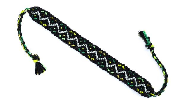 Multicolored woven DIY friendship bracelets handmade of embroidery bright thread with knots isolated on white background