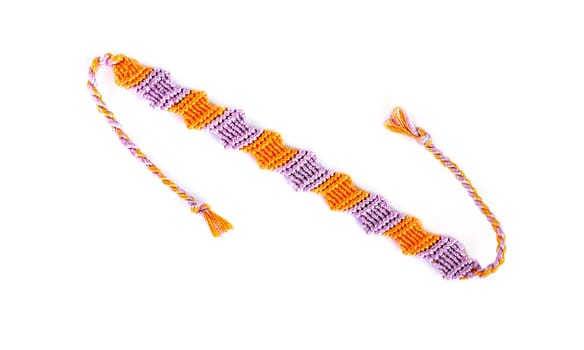 Multicolored woven DIY friendship bracelets handmade of embroidery bright thread with knots isolated on white background