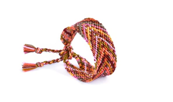 Multicolored woven DIY friendship bracelets handmade of embroidery bright thread with knots isolated on white background