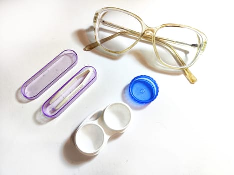 A pair of stylish glasses is sitting right next to a set of modern contact lenses, showcasing two popular eyewear options