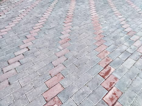 A patterned arrangement of paving stones creates a visually striking effect in a driveway.