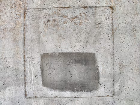 A weathered concrete wall displays a textured square frame with a faded area, providing ample space for promotional or informational text.