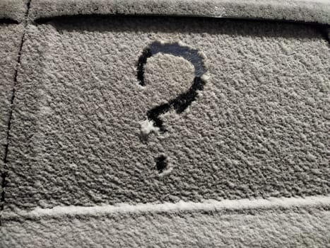 A question mark drawn on a frosted surface reflects feelings of insecurity and uncertainty in a business context during winter.