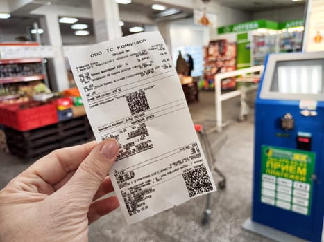 Krasnoyarsk, Russia - November 06, 2024: Receipt held in hand details transactions at a Krasnoyarsk store, showcasing the daily shopping experience in Russia.