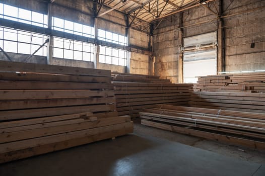 Stacked wooden planks close-up at lumber warehouse. Wood industry concept