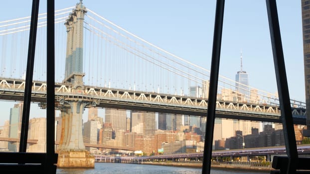 New York City, United States - 7 Sept 2023: Manhattan Bridge to Brooklyn. Pier 35 swings bench, waterfront downtown skyline cityscape. World Trade Center skyscraper, financial district morning sunset.