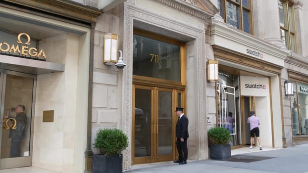 New York City, United States - 11 Sept 2023: Manhattan Midtown street, Fifth 5 avenue. American urban scene, USA. People pedestrians on sidewalk pavement. Boutique stores for luxury fashion shopping.
