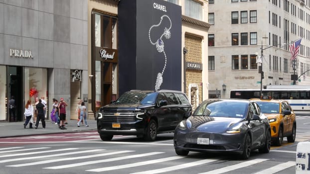 New York City, United States - 13 Sept 2023: Manhattan Midtown street, Fifth 5 avenue. American urban road car traffic. Yellow taxi in USA. People. Boutique fashion stores for shopping. Chanel, Prada.