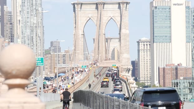 New York City, United States - 3 Sept 2023: Cars on Brooklyn Bridge from Manhattan downtown to Dumbo. Financial district skyline cityscape. Road traffic, people walking and USA architecture.