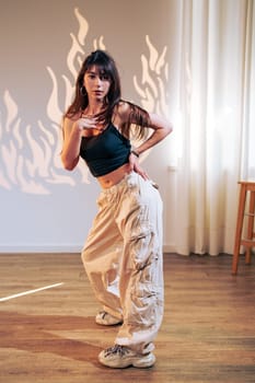 A dancer showcases her skills in a spacious studio, wearing casual attire. The warm light creates an artistic backdrop, enhancing her energetic movements.