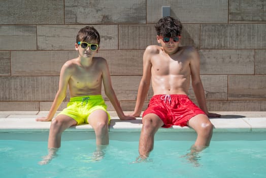 Boys enjoying a sunny day by the pool, wearing colorful swim trunks