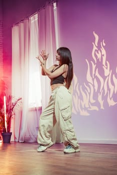A dancer showcases her contemporary movements in a bright studio filled with warm lighting. The creative shadow patterns add an artistic touch to her expressive performance.