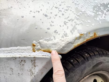 Close-up of a damaged car door revealing rust spots and surface deterioration indicating neglect or prolonged exposure to weather.