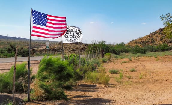 American flag and Route 66 flag waving in the desert along the historic road symbol of freedom and adventure in the USA