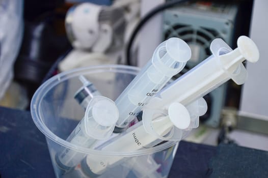used syringes put in a clear white container