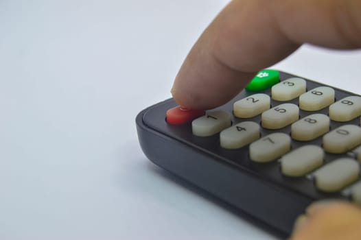 Close-up shot while pressing the remote control on a white background