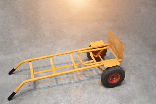 Yellow cart with black rubber wheels parked on concrete