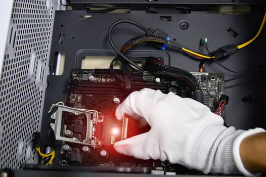 Image of a technician inserting a CPU chip onto a computer motherboard.