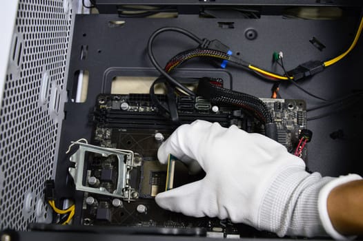 Image of a technician inserting a CPU chip onto a computer motherboard.