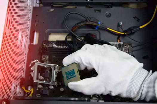 Image of a technician inserting a CPU chip onto a computer motherboard.