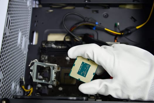 Image of a technician inserting a CPU chip onto a computer motherboard.
