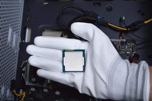 Picture of a hand wearing white gloves with a CPU chip placed on it.