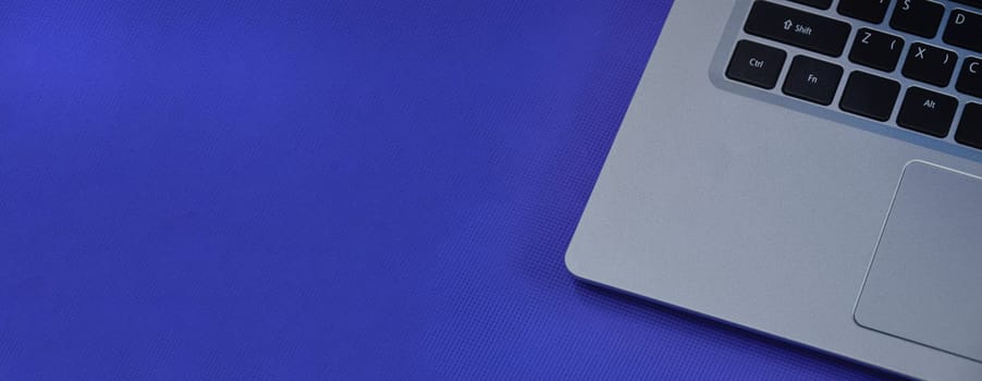 Left view of a white laptop on a blue background.