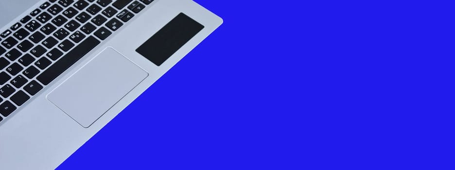 front view of white laptop on blue background