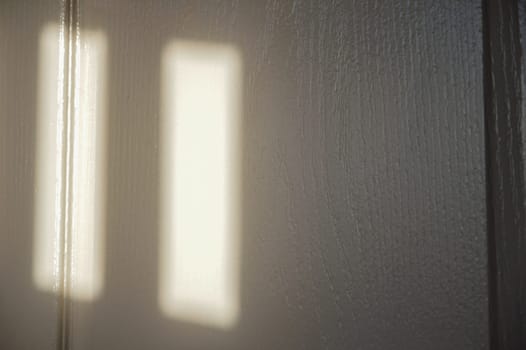 A picture of a wooden wall with red light shining through.