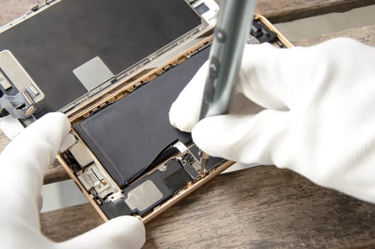 Top view, technician fixing a smartphone