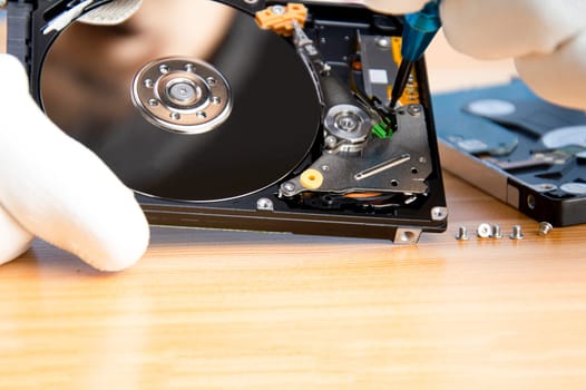 mechanic repairing hard drive, hard drive It is a device for storing data.