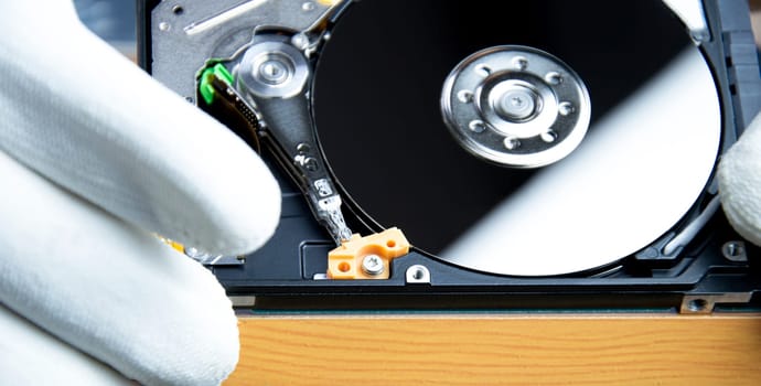 mechanic repairing hard drive, hard drive It is a device for storing data.