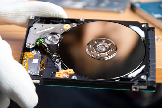 mechanic repairing hard drive, hard drive It is a device for storing data.