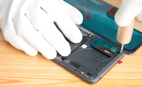 Image of a technician screwing the back of a mobile phone