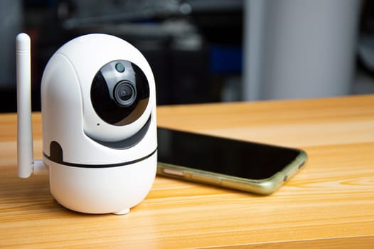 White ip camera lies on wooden floor