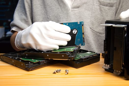 2.5-inch hard drives are still popular today, technician holding a hard drive in hand