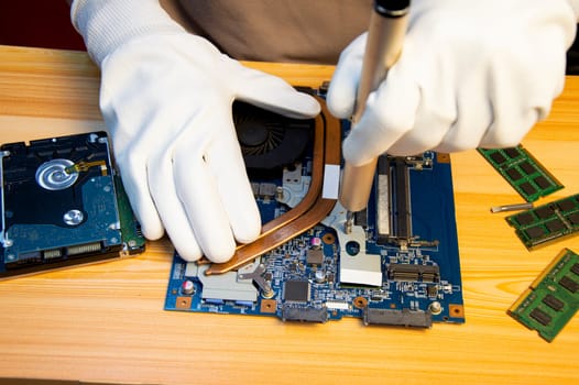 Technician repairing computer motherboard, notebook motherboard