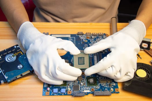 Technician repairing computer motherboard, notebook motherboard