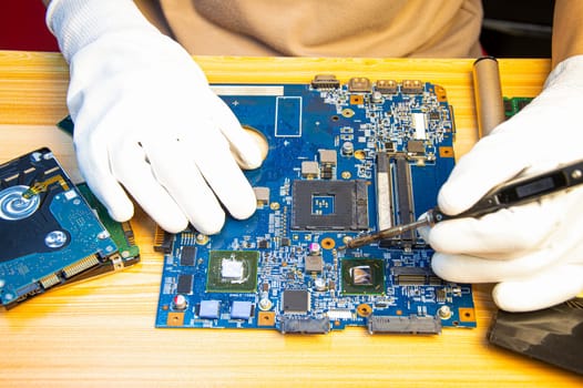 Technician repairing computer motherboard, notebook motherboard