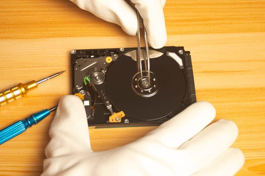 Top view of mechanic repairing hard drive
