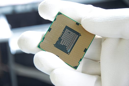 An image of a technician holding a CPU in his hand.
