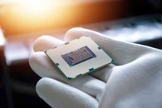 An image of a technician holding a CPU in his hand.